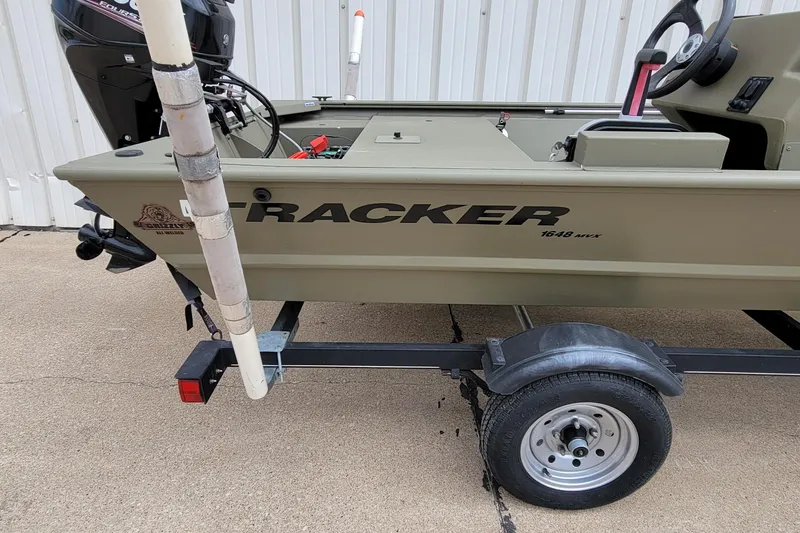 Slide: The Image of 2017 Tracker Grizzly 1648 SC boat on trailer, side view with motor visible. - 2