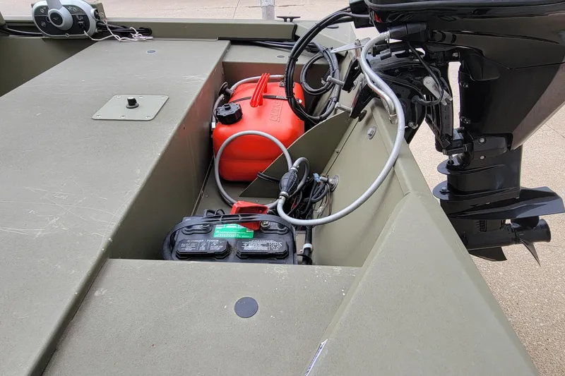 Slide: The Image of 2017 Tracker Grizzly 1648 SC boat interior with motor, battery, and fuel tank. - 5