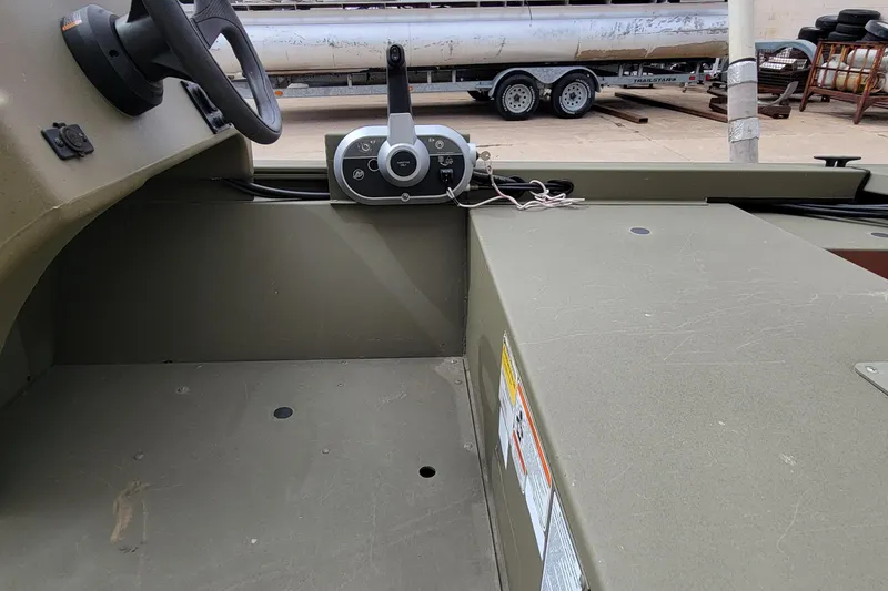 Slide: The Image of 2017 Tracker Grizzly 1648 SC boat interior with steering wheel and control panel. - 7