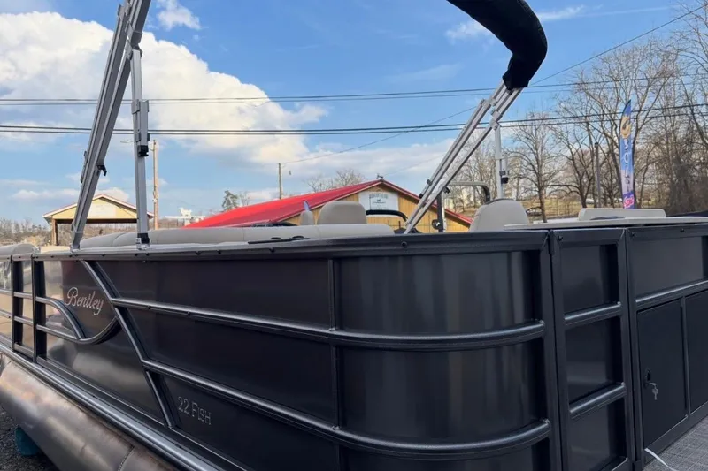 Slide: The Image of 2026 Bentley Pontoons Fish 220 N-Cruise pontoon boat with sleek design under blue sky. - 4