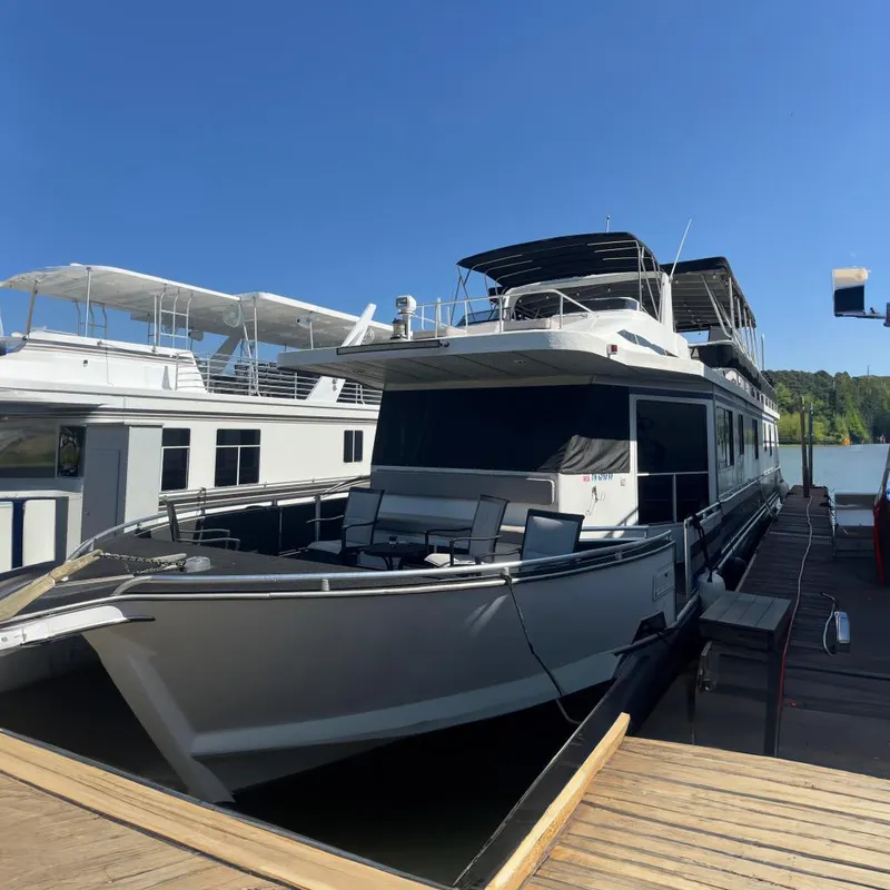 The Image of Houseboat docked at marina, Majestic Legacy 2005 model, under clear blue sky. - 0