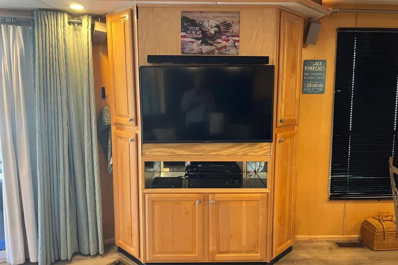 Slide: The Image of Entertainment center with TV and wooden cabinets in a 2005 Majestic Legacy RV. - 11