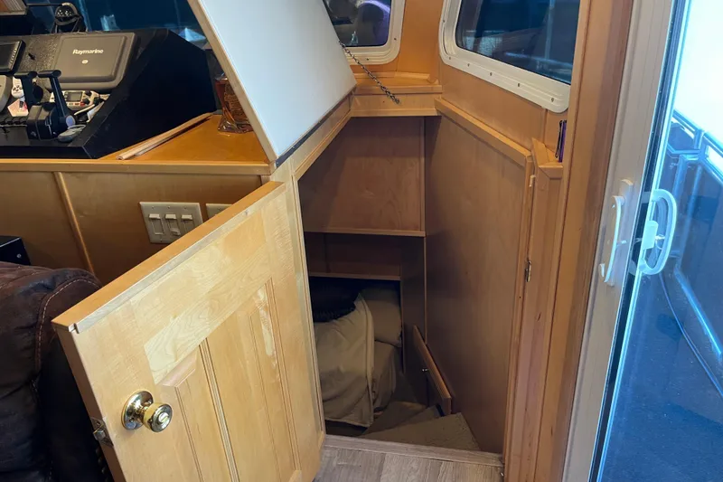 Slide: The Image of Wooden interior of a 2005 Majestic Legacy boat with open storage compartment. - 15