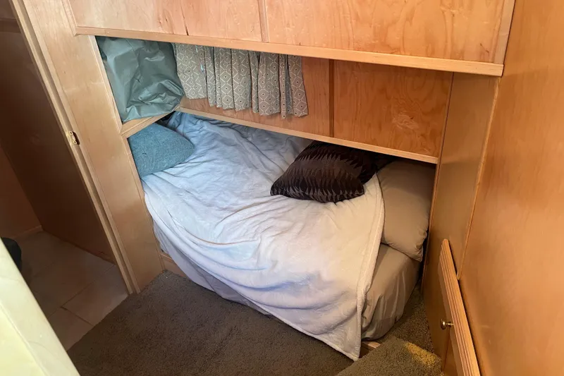 Slide: The Image of Cozy sleeping area in a 2005 Majestic Legacy RV with wooden cabinetry and soft bedding. - 18