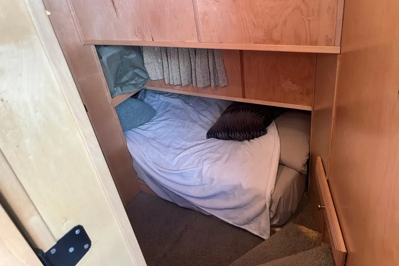 Slide: The Image of Cozy sleeping area in a 2005 Majestic Legacy RV with wooden cabinetry and soft bedding. - 19