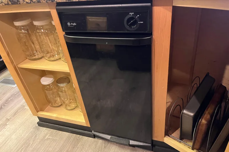 Slide: The Image of Black Majestic Legacy 2005 dishwasher in wooden kitchen cabinet with glass jars and baking trays. - 20