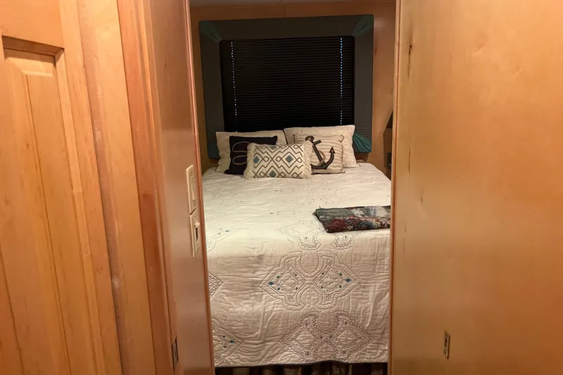 Slide: The Image of Cozy bedroom in a 2005 Majestic Legacy RV with nautical-themed pillows and quilt. - 22