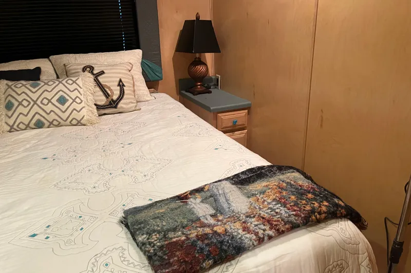 Slide: The Image of Cozy bedroom in 2005 Majestic Legacy RV with decorative pillows and a bedside lamp. - 24