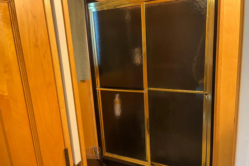 Slide: The Image of Golden-framed glass shower door in a wooden bathroom, Majestic Legacy 2005 model. - 29