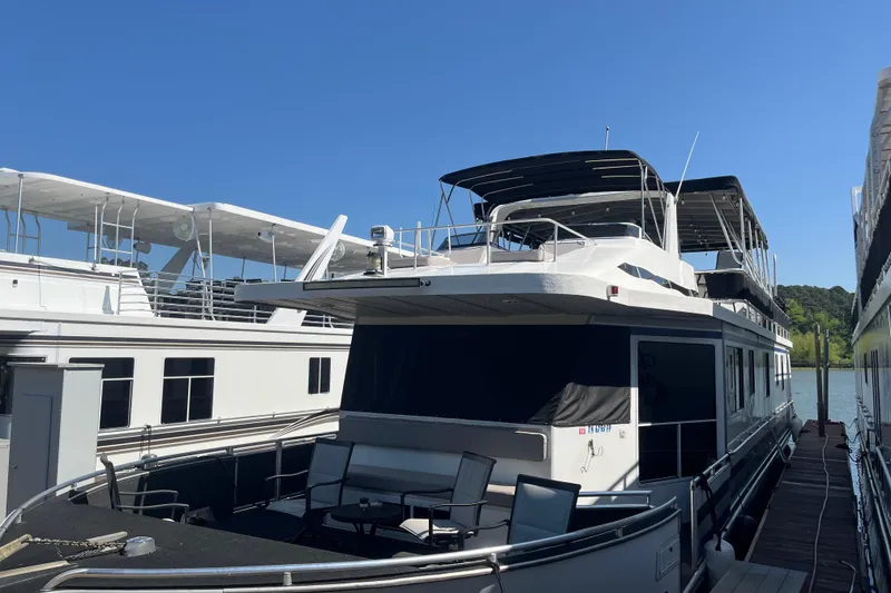 Slide: The Image of Houseboat docked at marina, Majestic Legacy 2005 model, under clear blue sky. - 3