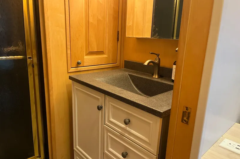 Slide: The Image of Compact bathroom sink with wooden cabinets in a 2005 Majestic Legacy model. - 31