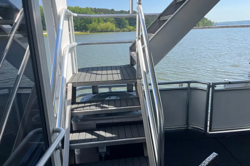 Slide: The Image of Staircase on a 2005 Majestic Legacy boat overlooking a serene lake. - 32