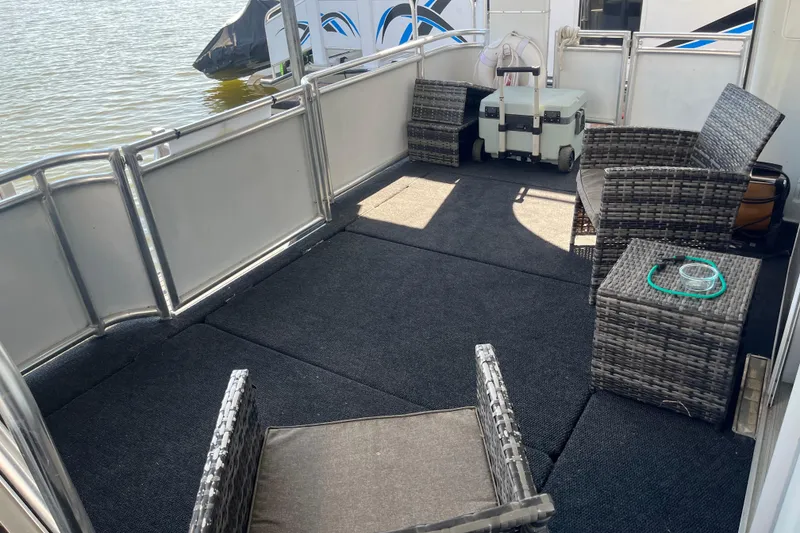 Slide: The Image of Outdoor seating area on a 2005 Majestic Legacy boat with wicker furniture and carpeted floor. - 33