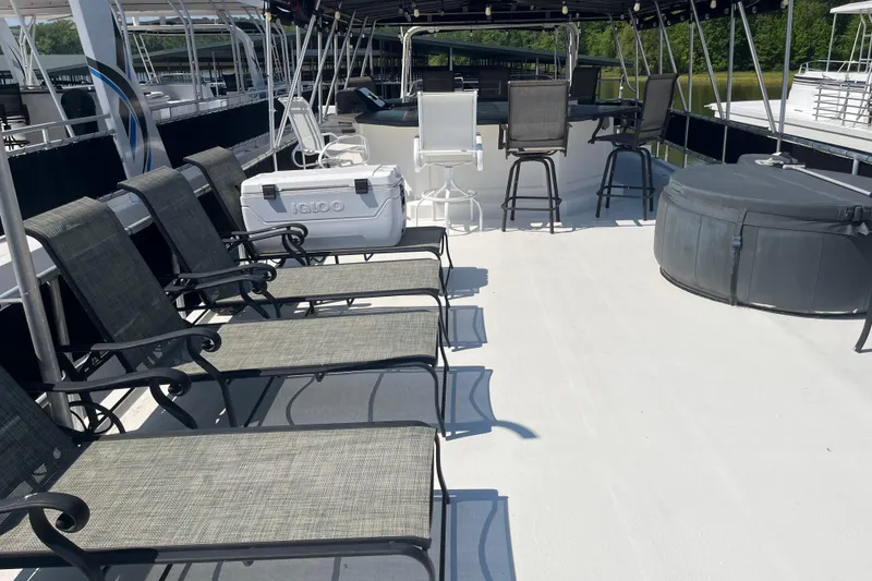 Slide: The Image of Upper deck of 2005 Majestic Legacy boat with chairs, cooler, and hot tub. - 36