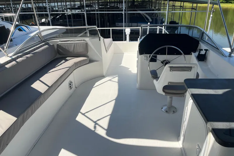 Slide: The Image of Spacious deck of a 2005 Majestic Legacy boat with seating and steering area. - 39