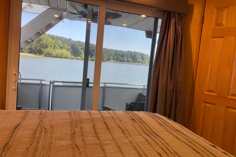 Slide: The Image of Bedroom view of a serene lake through sliding glass doors on a Majestic Legacy 2005 boat. - 43