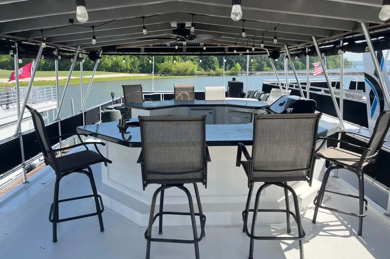 Slide: The Image of Luxurious 2005 Majestic Legacy boat deck with bar seating and scenic lake view. - 45