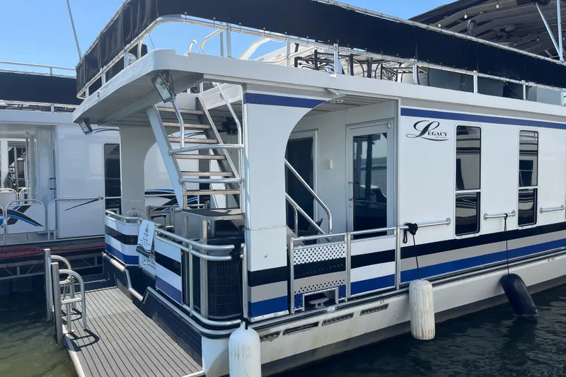 Slide: The Image of Houseboat Majestic Legacy 2005 docked, featuring sleek design and upper deck seating. - 47