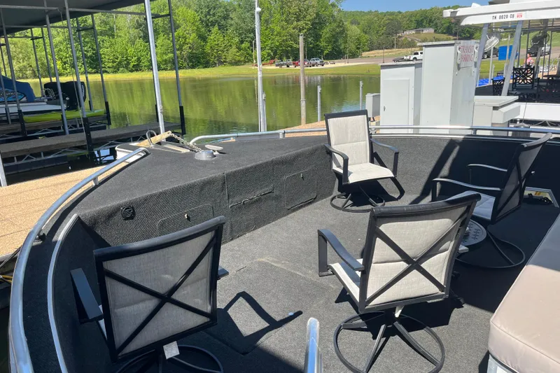 Slide: The Image of Deck of a 2005 Majestic Legacy boat with chairs, docked by a serene lake. - 6