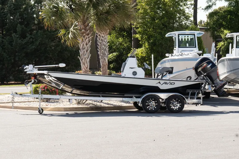 The Image of 2026 Avid 207 Recon boat on trailer, parked outdoors near palm trees. - 1