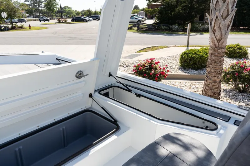 Slide: The Image of Open storage compartment in 2026 Avid 207 Recon boat, with scenic outdoor background. - 14