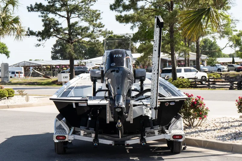 Slide: The Image of Avid 207 Recon 2026 boat on trailer, parked outdoors with trees and vehicles in background. - 5