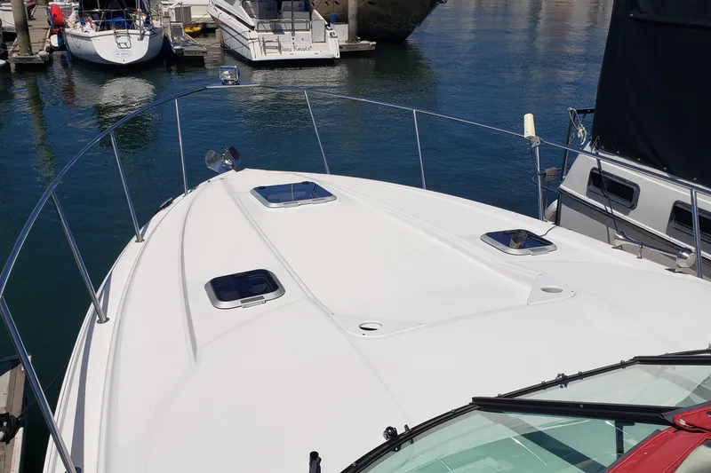 Slide: The Image of 2019 Rinker EX 370 boat docked in a marina, showcasing sleek deck design. - 10