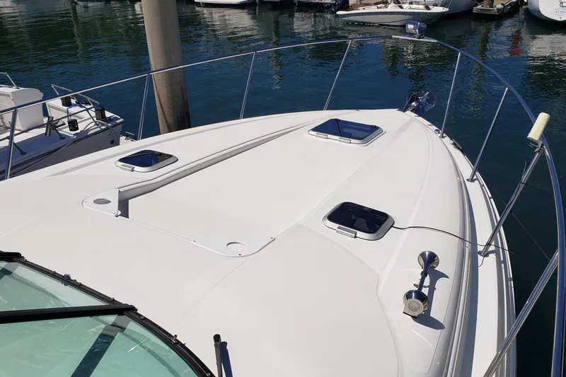 Slide: The Image of 2019 Rinker EX 370 boat deck with hatches, docked in a marina. - 11