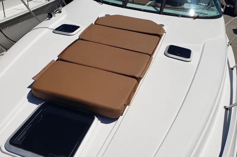 Slide: The Image of 2019 Rinker EX 370 boat deck with brown sun pads and hatches. - 14