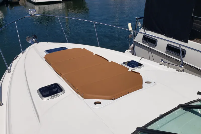Slide: The Image of 2019 Rinker EX 370 boat deck with sunpad, docked in marina. - 15