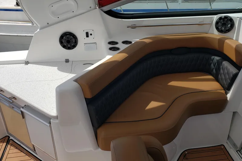 Slide: The Image of 2019 Rinker EX 370 boat interior with tan and black seating, speakers, and countertop. - 23