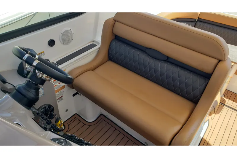 Slide: The Image of 2019 Rinker EX 370 boat interior with tan and black seating, steering wheel, and wood flooring. - 24
