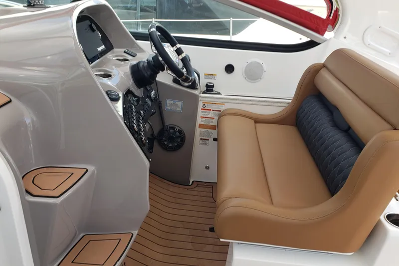 Slide: The Image of 2019 Rinker EX 370 boat interior with tan seating and modern dashboard controls. - 25