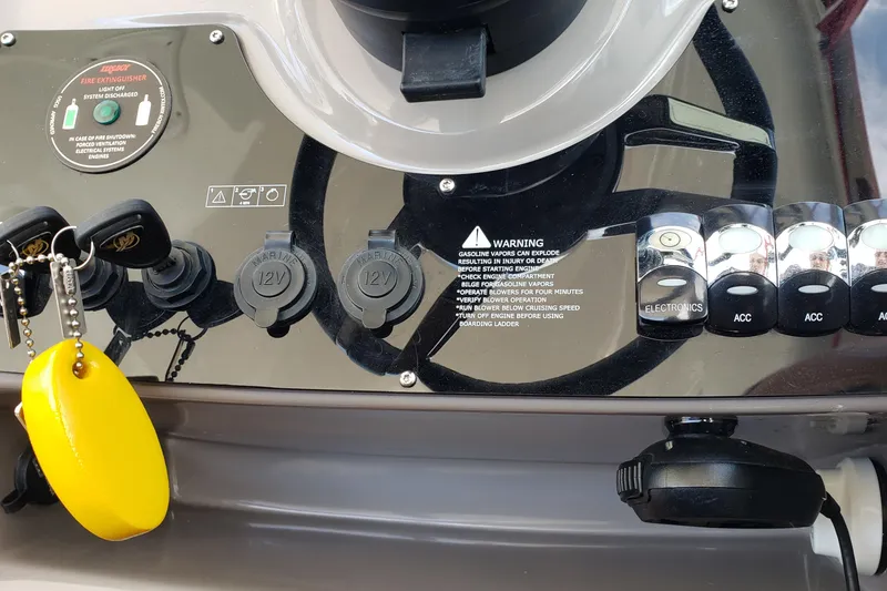 Slide: The Image of Control panel of a 2019 Rinker EX 370 boat with switches and warning labels. - 28