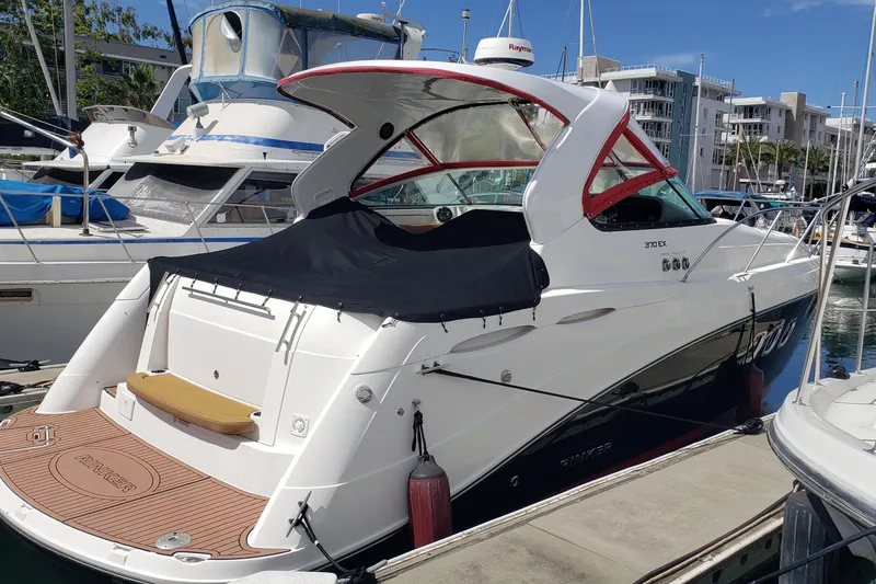 Slide: The Image of 2019 Rinker EX 370 boat docked at marina, featuring sleek design and covered deck. - 3