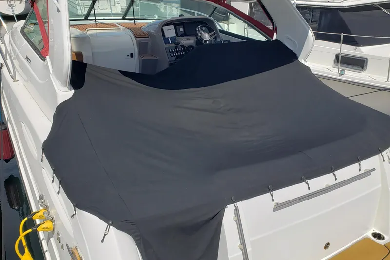 Slide: The Image of 2019 Rinker EX 370 boat with black cover, docked at marina. - 4
