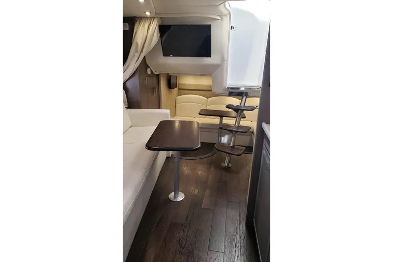Slide: The Image of 2019 Rinker EX 370 yacht interior with modern seating, table, and wooden flooring. - 42