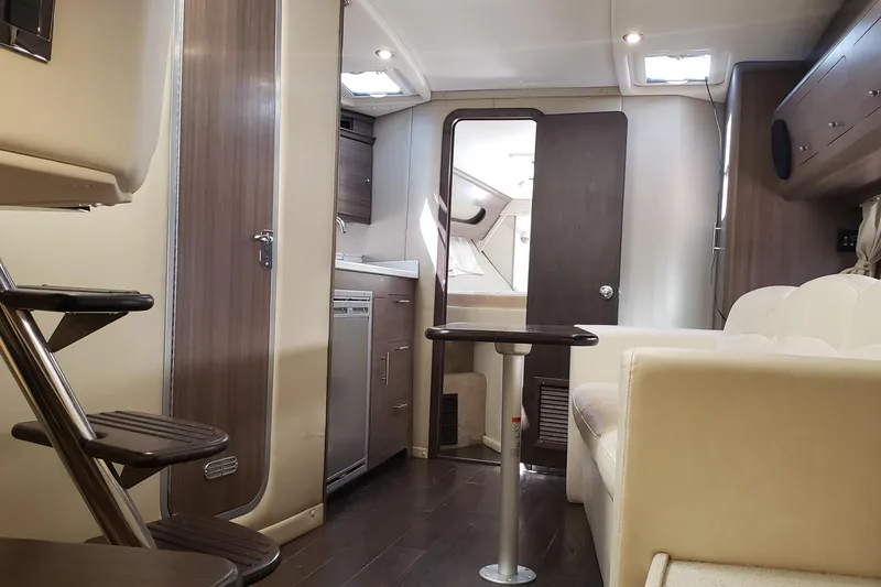 Slide: The Image of Interior of 2019 Rinker EX 370 boat, featuring modern kitchen and seating area. - 44