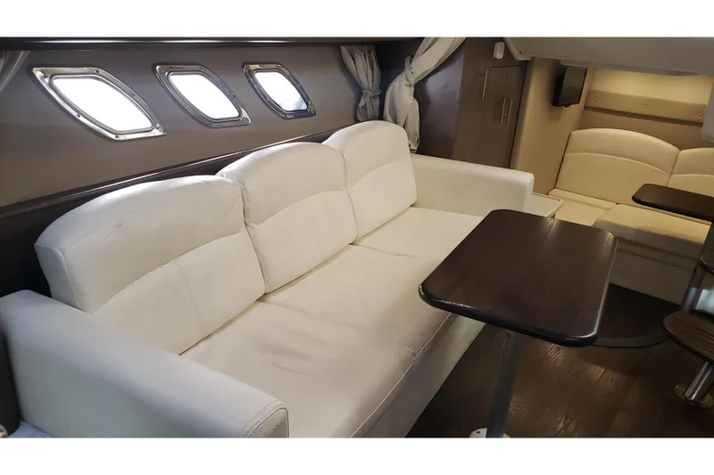 Slide: The Image of Interior of 2019 Rinker EX 370 yacht with white leather seating and wooden table. - 46