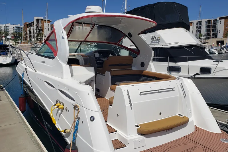 Slide: The Image of 2019 Rinker EX 370 yacht docked at marina, showcasing sleek design and spacious deck. - 5