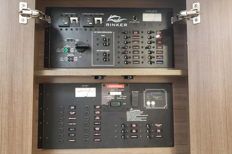 Slide: The Image of Control panel of a 2019 Rinker EX 370 boat, featuring AC and DC switches. - 59