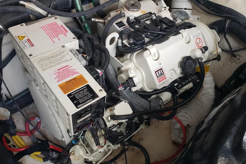 Slide: The Image of Engine compartment of a 2019 Rinker EX 370 boat, featuring complex wiring and components. - 63