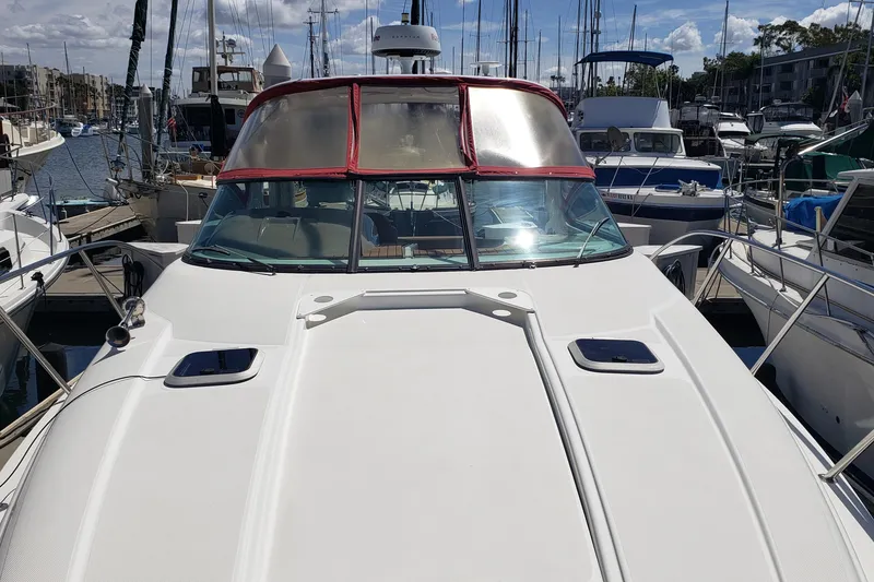 Slide: The Image of 2019 Rinker EX 370 boat docked at a marina, surrounded by other vessels. - 8