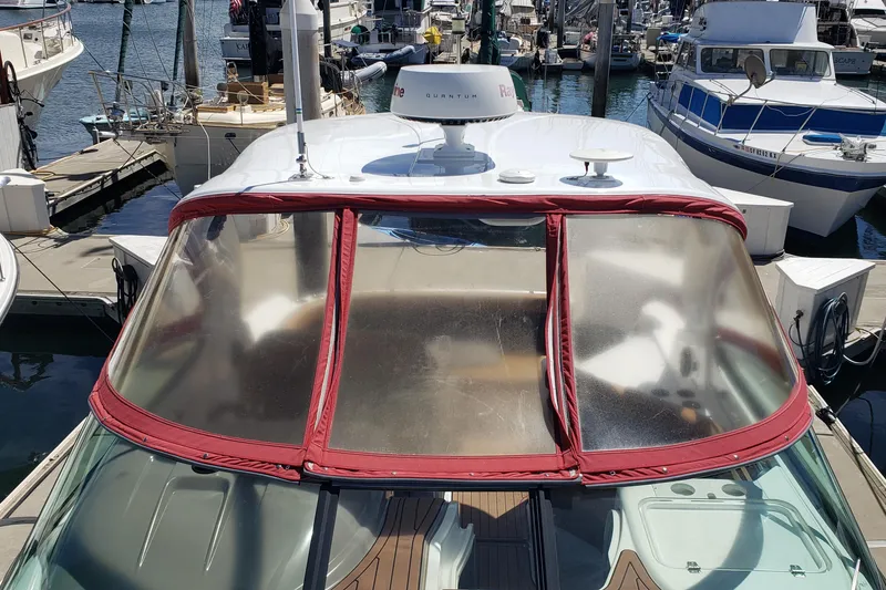 Slide: The Image of 2019 Rinker EX 370 boat docked at marina, featuring red-trimmed windshield. - 9