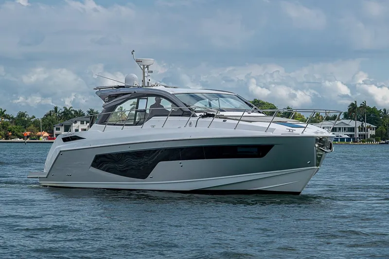 Slide: The Image of 2019 Azimut Atlantis 51 yacht cruising on a serene waterway under a cloudy sky. - 2