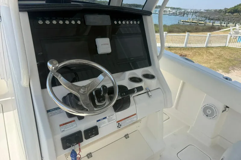 Slide: The Image of 2020 World Cat 280 CC-X boat helm with steering wheel and control panel. - 11