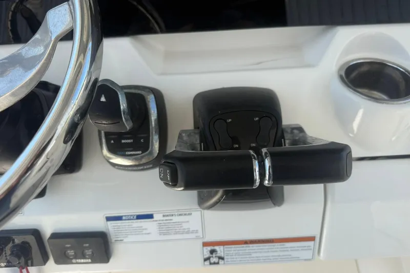 Slide: The Image of Control panel of a 2020 World Cat 280 CC-X boat with steering wheel and throttle. - 12