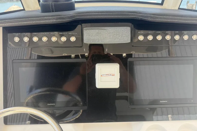 Slide: The Image of Control panel of 2020 World Cat 280 CC-X boat with Garmin displays and Optimus EPS system. - 13