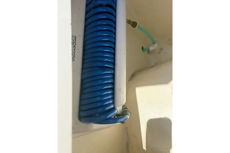Slide: The Image of Blue coiled hose in a 2020 World Cat 280 CC-X boat compartment. - 20