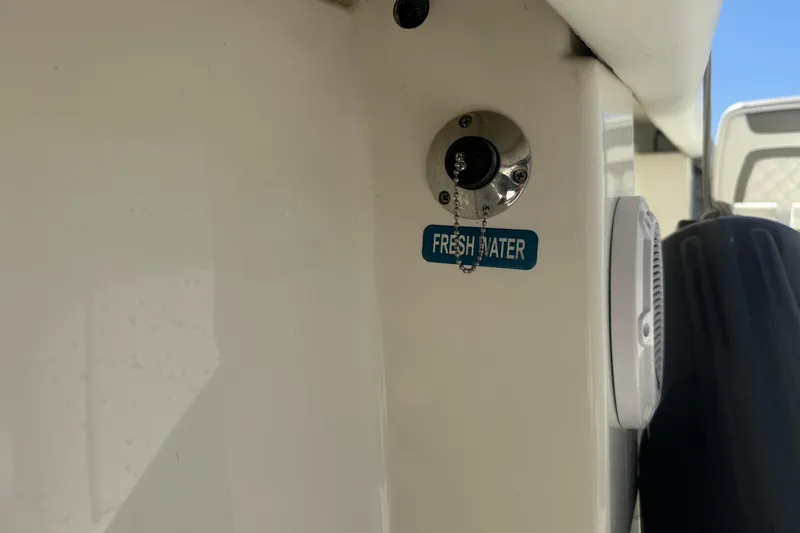 Slide: The Image of Freshwater inlet on 2020 World Cat 280 CC-X boat, featuring a secure cap and label. - 26